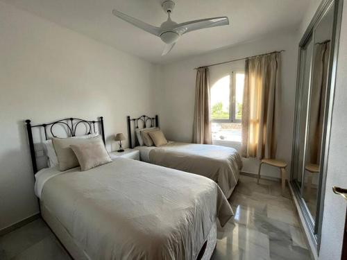 um quarto com 2 camas e uma ventoinha de tecto em Apartamento con vista al mar em Mijas Costa