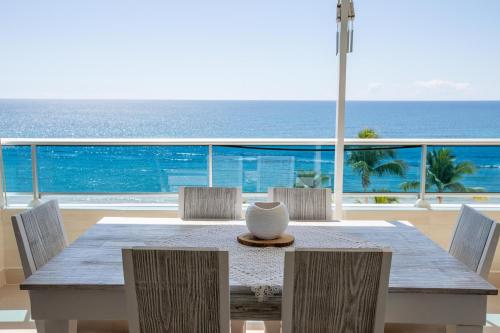 una mesa y sillas con vistas al océano en Las Olas Juan Dolio Beachfront View, en Juan Dolio