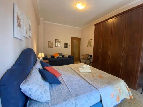 a bedroom with a blue bed and a couch at Mammo's House in Rome