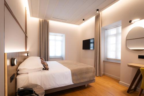 a bedroom with a bed and a mirror and a desk at Navria by Aetoma in Nafplio