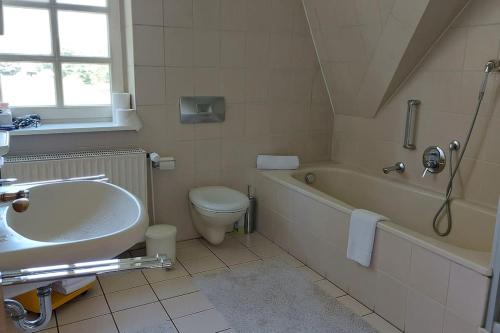 a bathroom with a sink and a tub and a toilet at Das Refugium in Worpswede