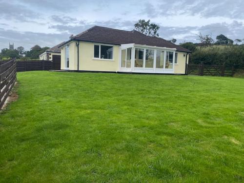 a house with a large lawn in front of it at Bungalow in Pillaton in Saltash