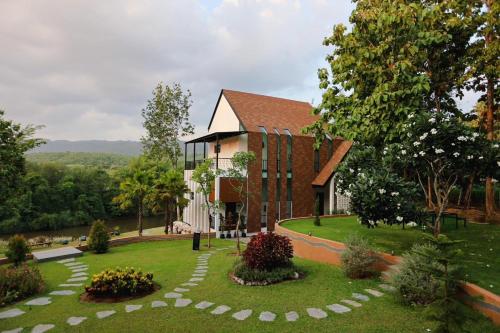 a building with a garden in front of it at VeeVaree Riverkwai Resort in Ban Kaeng Raboet