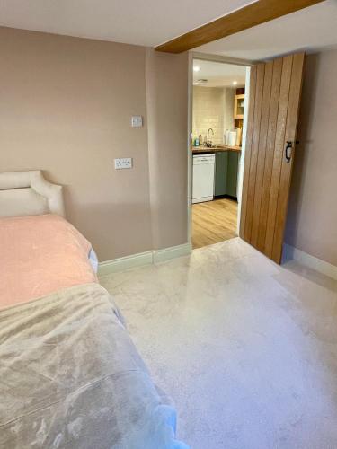 an empty room with a bed and a kitchen at The Grannery in Wadhurst