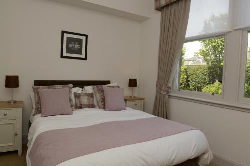 a bedroom with a bed with pillows and a window at WM Apartments in Edinburgh