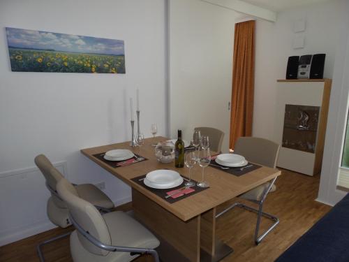 a dining room with a table with chairs and wine glasses at DünenResort in Binz, strandnahe und moderne FeWos mit Balkon, teilweise mit Meerblick, in Binz