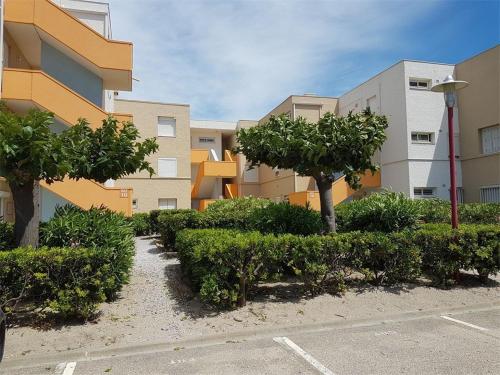 une rangée d'arbres et de buissons devant un bâtiment dans l'établissement DEUX PIECES 4 PERSONNES FACE PLAGE 4GL1C204, au Barcarès