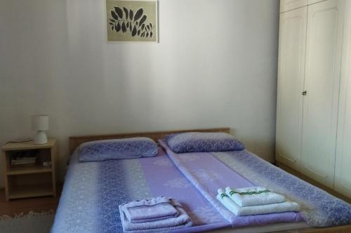 Un dormitorio con una cama morada con toallas. en Apartman "Milka" Bajina Bašta en Bajina Bašta