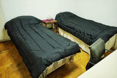 ブエノスアイレスにあるPalacio Lugones - Terraza Premiumのベッド2台、テーブル、椅子が備わる客室です。