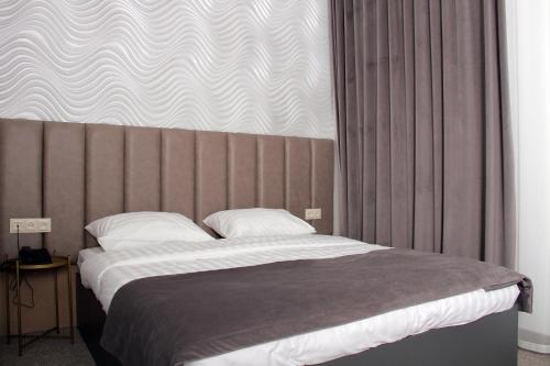 a bedroom with a large bed and a large window at Port Plaza EVN in Pʼarakʼar