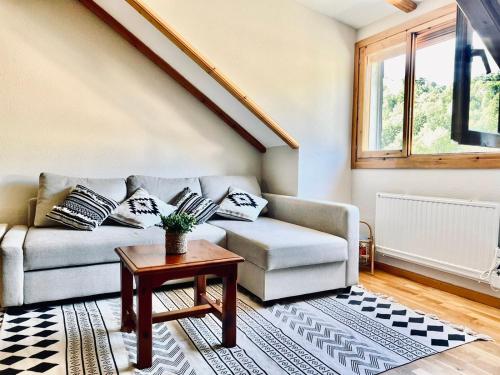 a living room with a couch and a table at Arriel 28:24 in Escarrilla