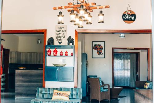 uma sala de estar com um sofá e um lustre em The Kraal em Mbarara