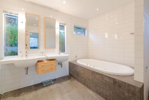 a bathroom with a tub and a sink and a bath tub at Lake View Villa, Great location and Amazing views in Queenstown