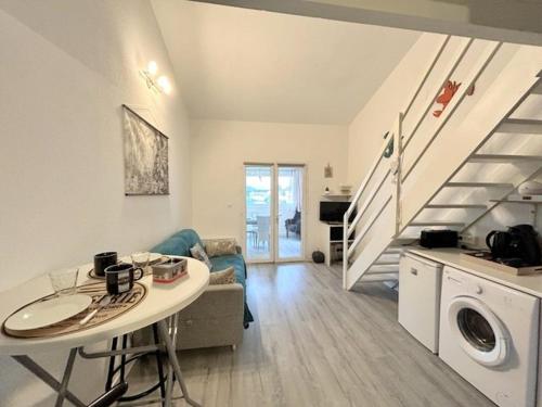 un salon avec une table et un escalier dans l'établissement APPARTEMENT 4 personnes - 500 m plage - 4GOEL53, au Barcarès