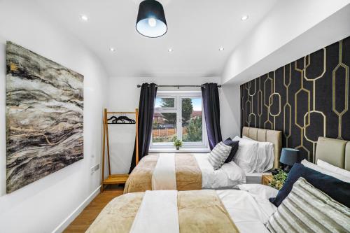 um quarto com 2 camas e uma janela em Exquisite London Home - Parking - Sleeps 10 em Dagenham