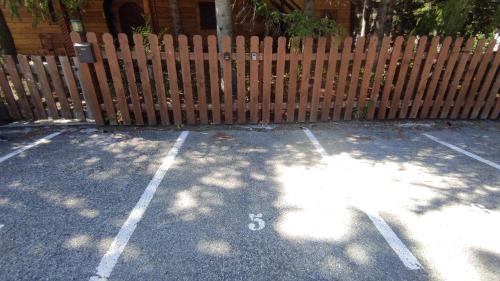 a parking lot in front of a wooden fence at Studio Les 3 Lys Auron in Auron