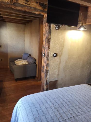 a bedroom with a bed and a couch in a room at La Casa El Cura in Madrigal de la Vera
