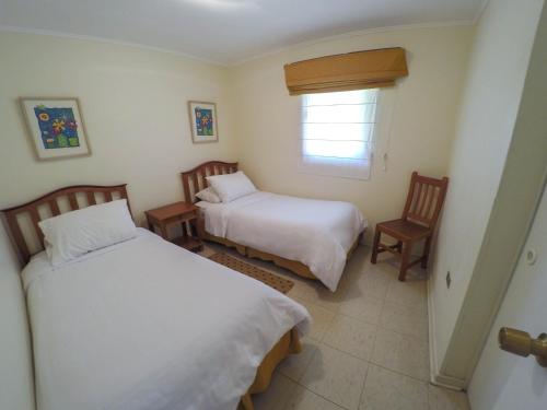 1 dormitorio con 2 camas y ventana en Cabañas La Huayca - Caja Los Andes, en Pica