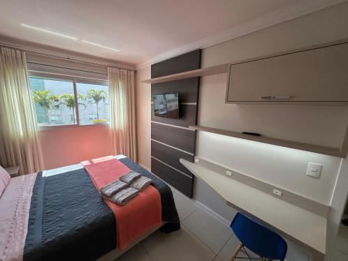 - une chambre avec un lit et une télévision à écran plat dans l'établissement Apartamento de frente para Piscina, com vista para o mar, à Florianópolis