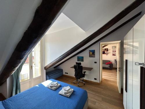 Un dormitorio con una cama azul y un escritorio en una habitación en La Mansardina, en Turín