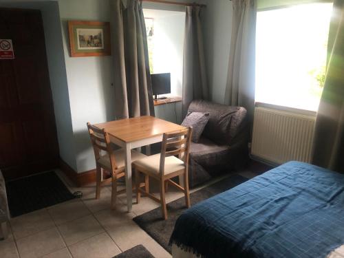 a room with a table and a chair and a bed at Riverside apartment in Brecon