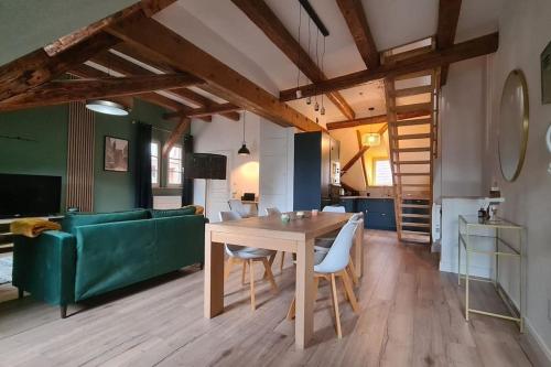 a living room with a table and a green couch at Duplex Centre - Le Marché in Obernai