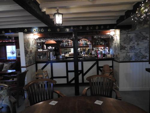 a bar in a restaurant with a table and chairs at The Bay Horse Hotel And Restaurant in Ulverston