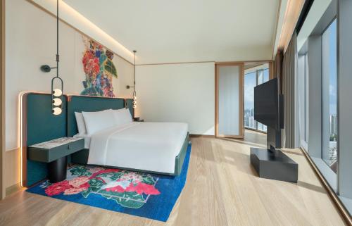 a hotel room with a bed and a tv at W Macau - Studio City in Macau