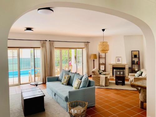 un soggiorno con divano blu e camino di Villa in Praia D'el Rey, Beach & Golf Resort a Casal da Lagoa Seca