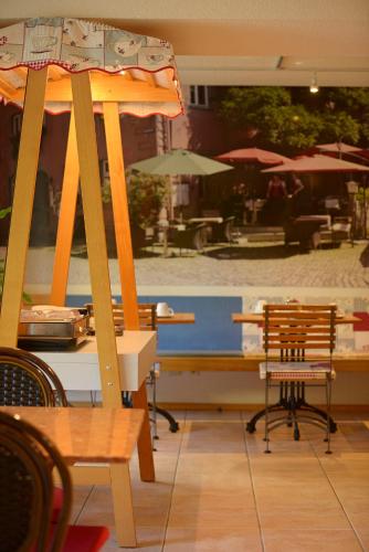 a patio with tables and chairs and an umbrella at Gästehaus Goethe in Staufen im Breisgau