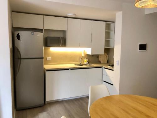 a kitchen with white cabinets and a refrigerator at NvaCba Premium: a mts Pque de las Tejas, 1 dorm PB con patio, confort y diseño - ALOHA #4 in Cordoba