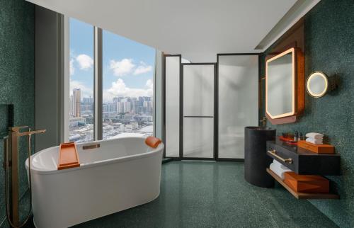 a bathroom with a tub and a large window at W Macau - Studio City in Macau