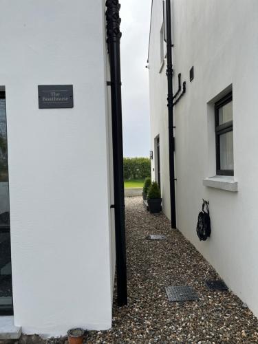 a hallway of a white building with a sign on it at The Boathouse in Donaghadee
