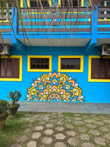 a blue building with a colorful mural on the side of it at Pousada Retiro das Caravelas in Cananéia