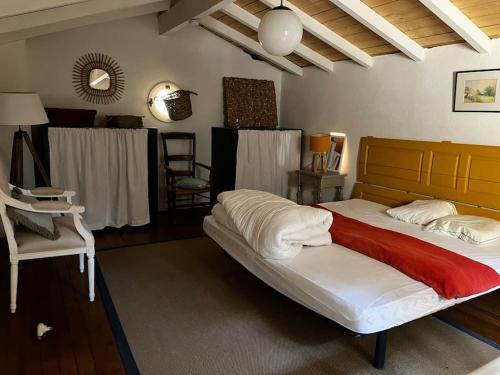 a bedroom with a large bed and a chair at Véritable Bastidon Provençale in Le Tholonet