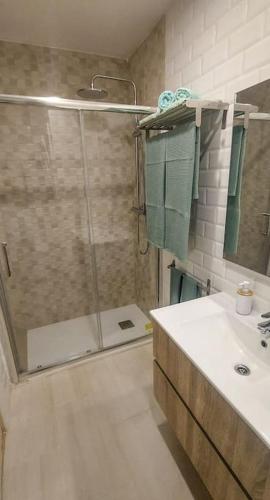a bathroom with a shower and a sink with a glass door at La puerta al Mar in Calafell