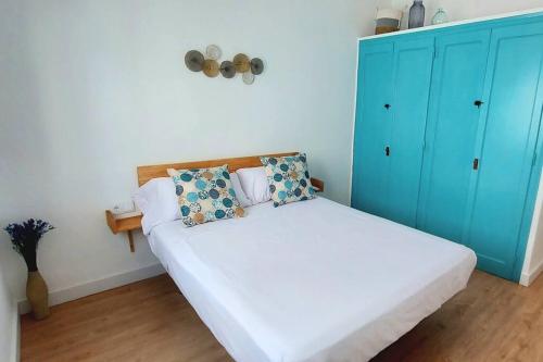 a bedroom with a bed with a blue cabinet at La puerta al Mar in Calafell