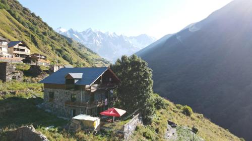 uma casa ao lado de uma montanha em Gaul Gavkhe Hotel em Ushguli