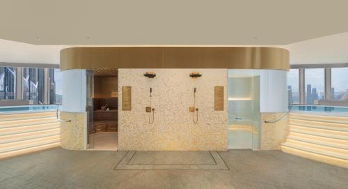 a bathroom with four shower stalls in a building at W Macau - Studio City in Macau