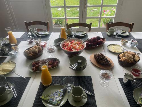 a table topped with plates and bowls of food at Les Hortensias in Espoey