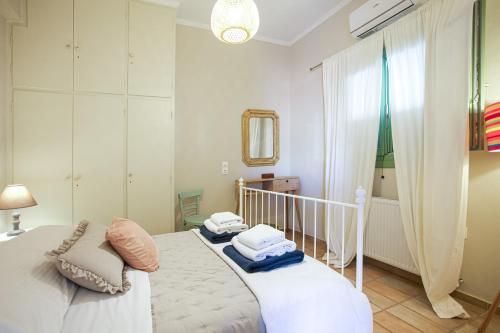 una camera da letto con un letto bianco con asciugamani sopra di Thalia Kassiopi Apartment a Kassiopi