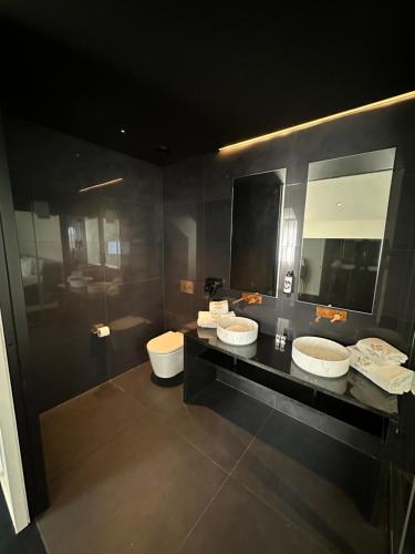 a bathroom with two sinks and two mirrors at Golden Lisbon Hotel in Lisbon