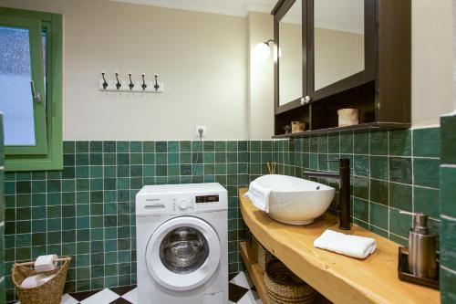 un bagno con lavatrice e lavandino di Thalia Kassiopi Apartment a Kassiopi