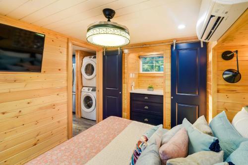a bedroom with a couch and a washer and dryer at about 11 Mi to Lake Whitney Tree-Lined Cabin with Deck in Whitney