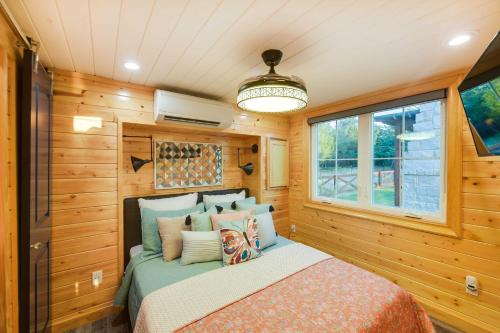 a bedroom with a bed in a room with wooden walls at Tree-Lined Whitney Cabin about 11 Mi to Lake Whitney! in Whitney