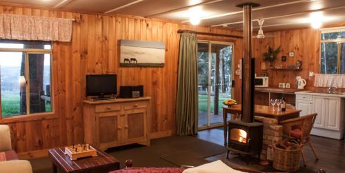 a living room with a fireplace and a stove at Balingup Heights Hilltop Forest Cottages in Balingup
