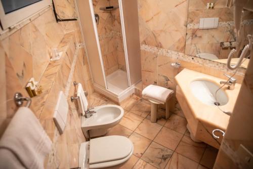 a bathroom with a sink and a toilet at Grand Hotel Duomo in Pisa