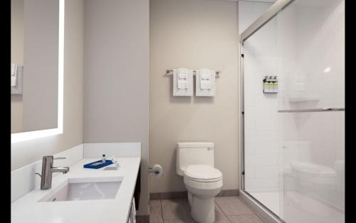 a white bathroom with a toilet and a shower at Holiday Inn Express Cape Canaveral by IHG in Cape Canaveral