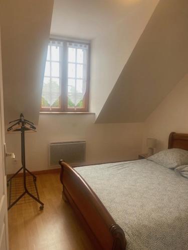 ein Schlafzimmer mit einem Bett im Dachgeschoss mit einem Fenster in der Unterkunft Les Terrasses Des Rossignols in Chémery