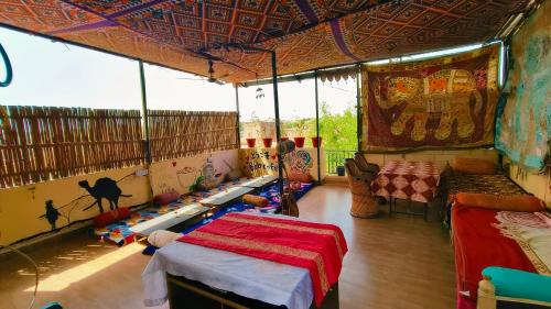 a room with a tent with a bed and a couch at Bob Cafe & Guest House Jaisalmer in Jaisalmer
